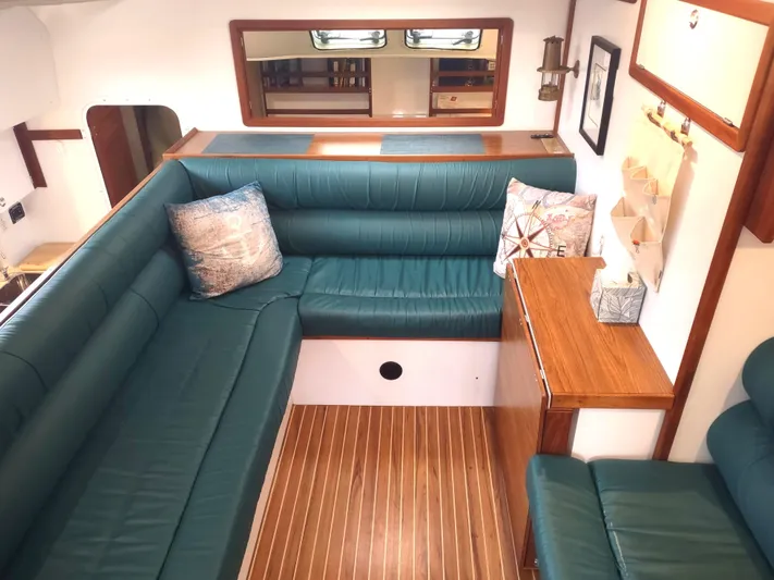 Journey Yacht Photos Pics Interior of 2002 Endeavour Trawlercat 36 with green seating and wooden accents.