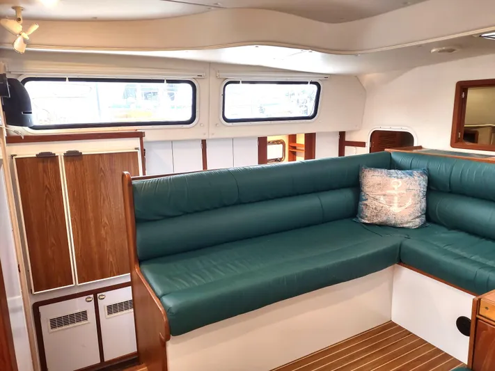 Journey Yacht Photos Pics Interior of 2002 Endeavour Trawlercat 36 with green seating and wood accents.