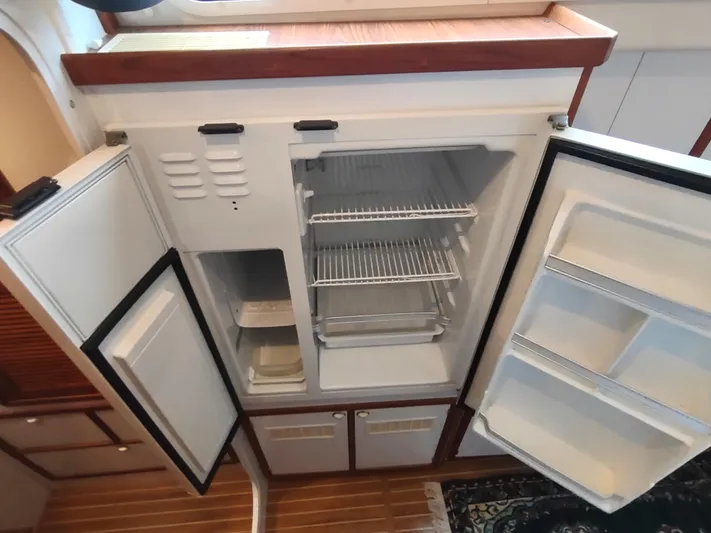 Journey Yacht Photos Pics 2002 Endeavour Trawlercat 36 galley with open refrigerator and wooden flooring.