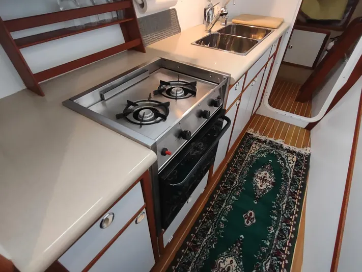 Journey Yacht Photos Pics 2002 Endeavour Trawlercat 36 kitchen with stove, sink, and elegant rug.