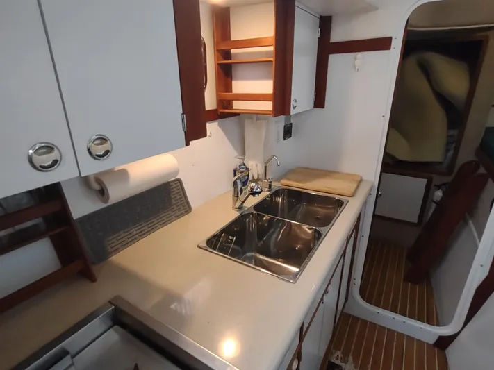 Journey Yacht Photos Pics Compact kitchen in 2002 Endeavour Trawlercat 36 with dual sinks and wooden cabinetry.