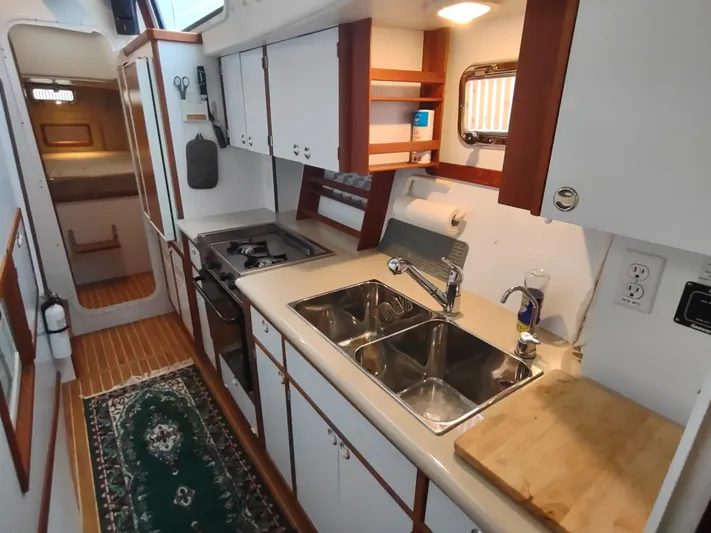 Journey Yacht Photos Pics 2002 Endeavour Trawlercat 36 kitchen with dual sink, stove, and wooden accents.