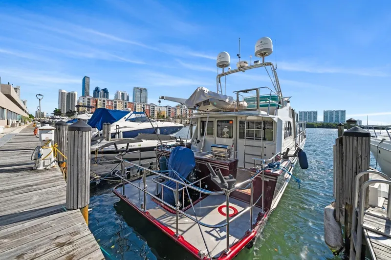 Oberwolf Yacht Photos Pics EagleCraft 47' Pilothouse 2009 docked at marina with city skyline backdrop.