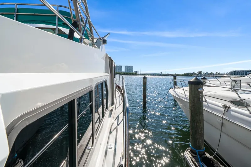 Oberwolf Yacht Photos Pics 2009 EagleCraft 47' Pilothouse yacht docked in sunny marina, sparkling water view.