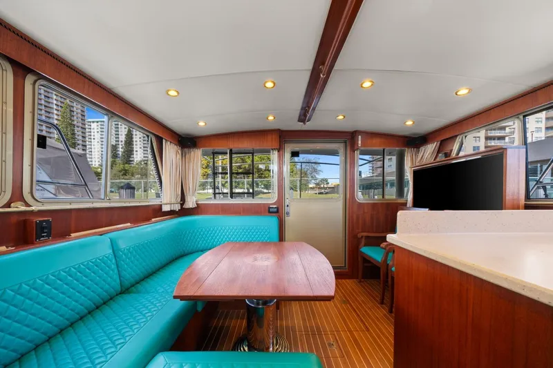 Oberwolf Yacht Photos Pics Interior of 2009 EagleCraft 47' Pilothouse with teal seating and wooden table.
