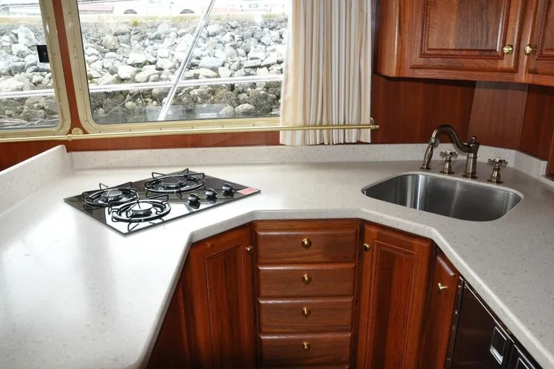 Oberwolf Yacht Photos Pics Luxurious kitchen in 2009 EagleCraft 47' Pilothouse with stove, sink, and wooden cabinetry.