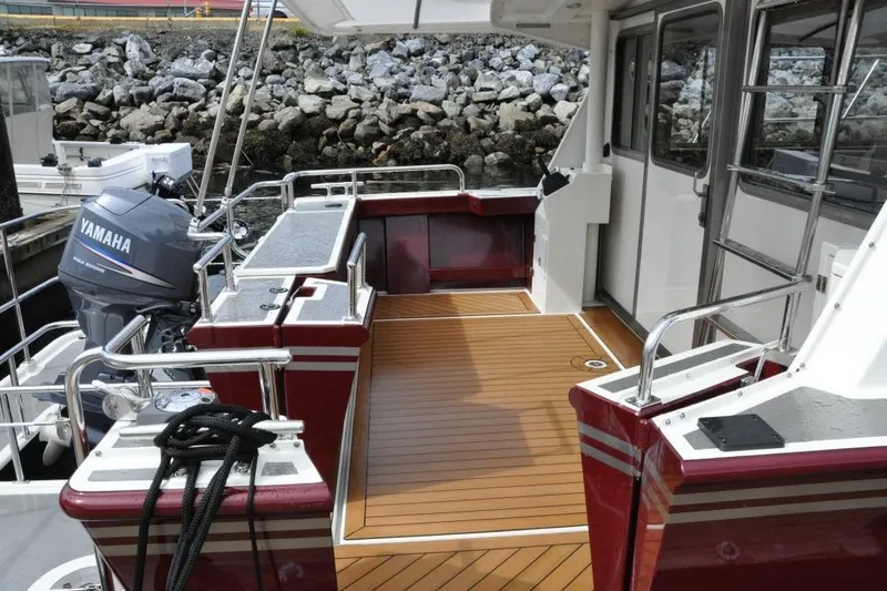 Oberwolf Yacht Photos Pics 2009 EagleCraft 47' Pilothouse boat deck with Yamaha motor, docked by rocky shore.