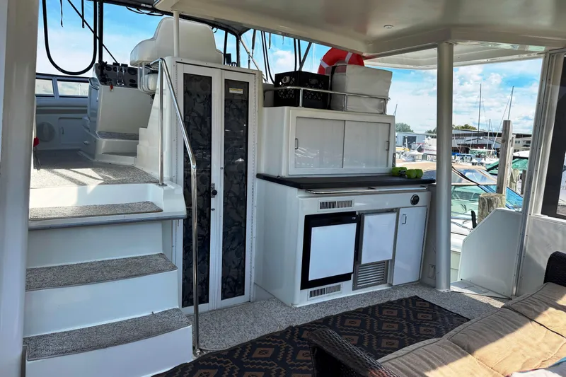  Yacht Photos Pics 1997 Carver 445 Aft Cabin Motor Yacht interior with kitchenette and stairs, docked at marina.