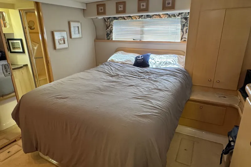  Yacht Photos Pics Cozy bedroom in 1997 Carver 445 Aft Cabin Motor Yacht with double bed and wooden cabinetry.