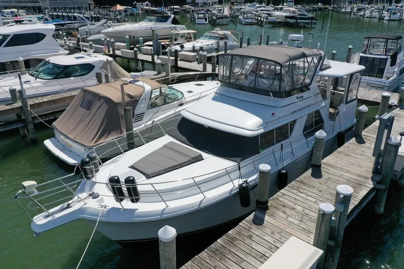  Yacht Photos Pics 1997 Carver 445 Aft Cabin Motor Yacht docked at marina, surrounded by other boats.