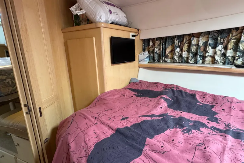  Yacht Photos Pics Cozy cabin interior of 1997 Carver 445 Aft Cabin Motor Yacht with map-themed bedding.