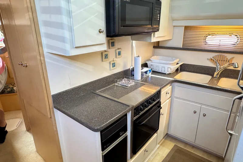  Yacht Photos Pics 1997 Carver 445 Aft Cabin Motor Yacht kitchen with stove, microwave, and sink.
