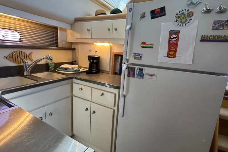  Yacht Photos Pics 1997 Carver 445 Aft Cabin Motor Yacht kitchen with fridge, sink, and cabinets.