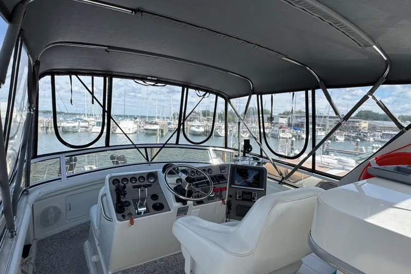  Yacht Photos Pics 1997 Carver 445 Aft Cabin Motor Yacht helm with marina view, featuring navigation equipment.