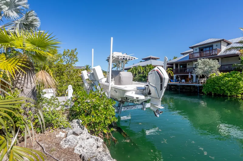  Yacht Photos Pics 2017 SeaVee 270Z boat docked by waterfront homes, surrounded by lush greenery.