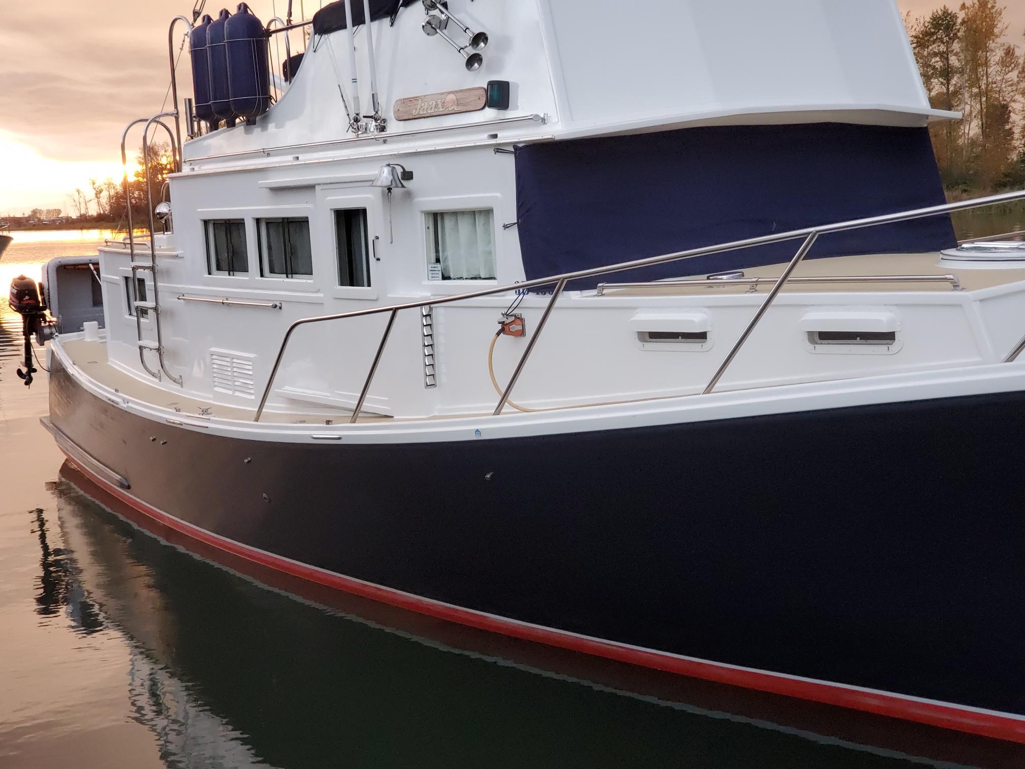 1970 Custom Tri-Cabin boat on calm water at sunset.