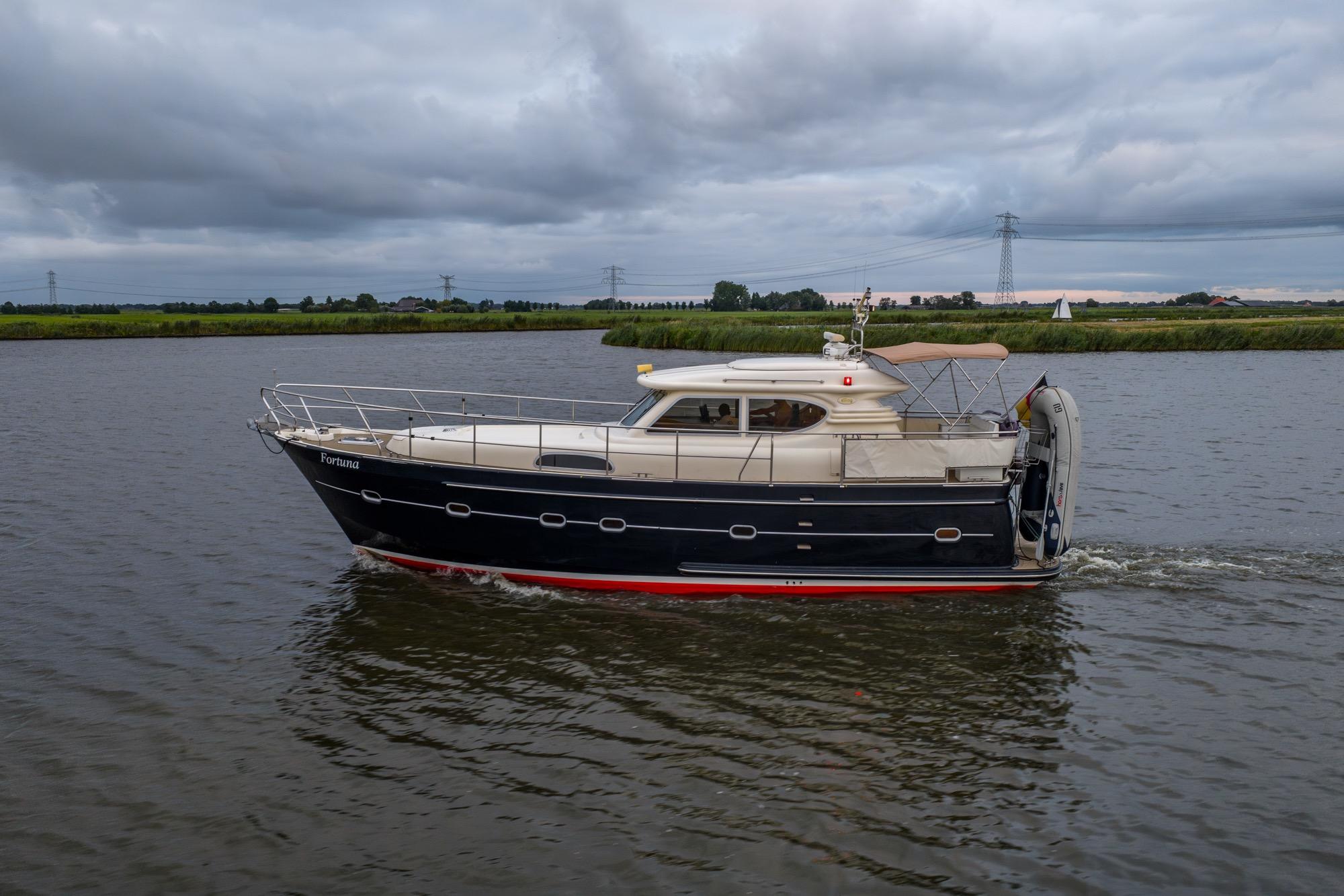 2001 Elling E3 Ultimate yacht cruising on a calm river under cloudy skies.