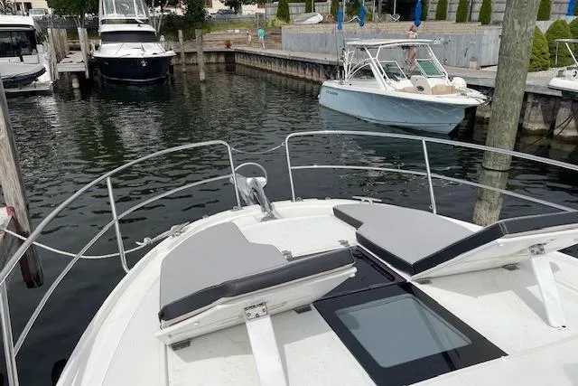  Yacht Photos Pics 2020 Jeanneau NC 1095 Fly yacht docked in a marina, featuring spacious deck seating.