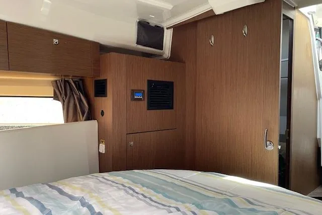  Yacht Photos Pics Interior cabin of 2020 Jeanneau NC 1095 Fly with wood paneling and bed.