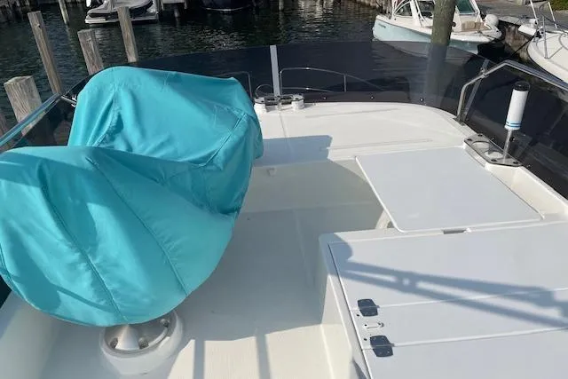  Yacht Photos Pics 2020 Jeanneau NC 1095 Fly deck with turquoise-covered seating and table, docked at marina.