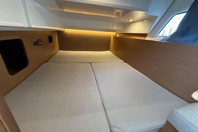  Yacht Photos Pics 2020 Jeanneau NC 1095 Fly cabin interior with cozy bedding and modern lighting.