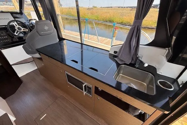  Yacht Photos Pics Interior of 2020 Jeanneau NC 1095 Fly, featuring sleek kitchen and helm station.
