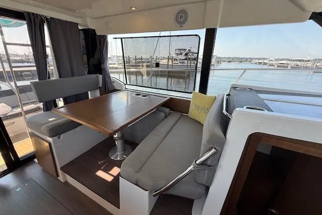  Yacht Photos Pics Interior of 2020 Jeanneau NC 1095 Fly yacht with dining area and marina view.