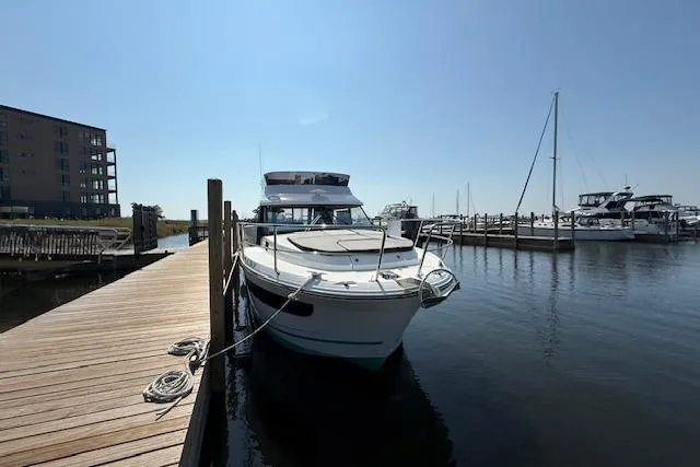  Yacht Photos Pics 2020 Jeanneau NC 1095 Fly moored at a marina dock under clear skies.