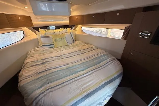  Yacht Photos Pics 2020 Jeanneau NC 1095 Fly cabin with cozy bed and striped bedding.