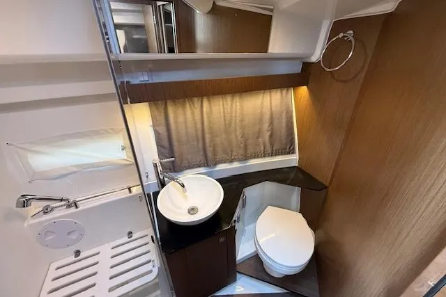  Yacht Photos Pics 2020 Jeanneau NC 1095 Fly bathroom with modern fixtures and wood accents.