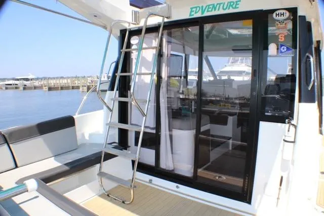  Yacht Photos Pics 2020 Jeanneau NC 1095 Fly yacht with outdoor seating and ladder, docked at marina.