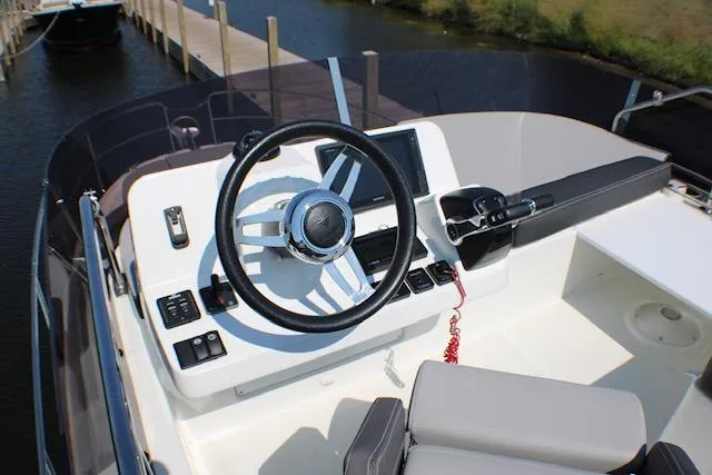  Yacht Photos Pics 2020 Jeanneau NC 1095 Flybridge helm with steering wheel and control panel.