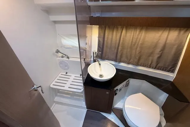  Yacht Photos Pics 2020 Jeanneau NC 1095 Fly bathroom with modern fixtures and compact design.