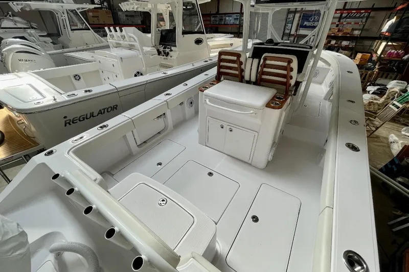  Yacht Photos Pics 2023 Jupiter 32 boat interior with seating and storage, docked alongside a Regulator vessel.