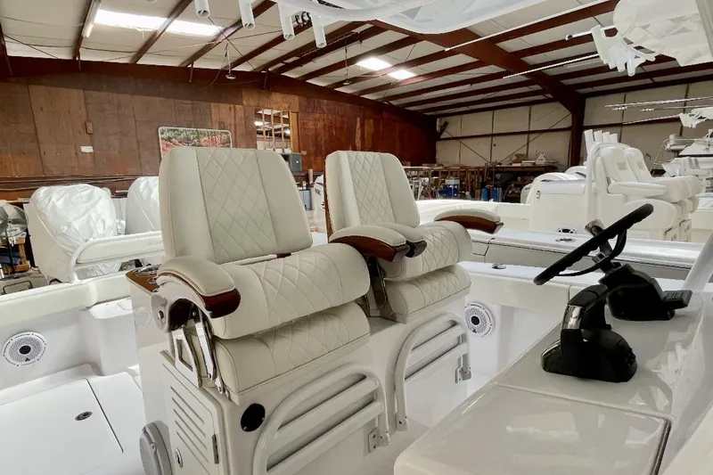  Yacht Photos Pics 2023 Jupiter 32 boat interior with luxurious white seating and steering wheel.