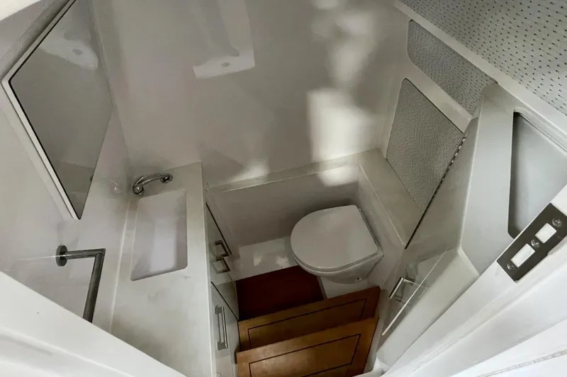  Yacht Photos Pics Compact bathroom in 2023 Jupiter 32 boat with sink, toilet, and mirror.