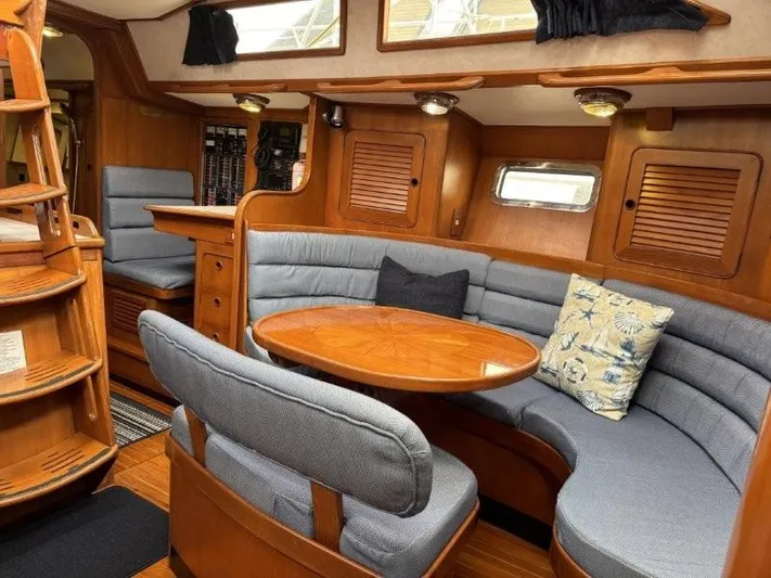 Seacape Yacht Photos Pics Cozy interior of 1996 Hylas 46 yacht with wooden furnishings and cushioned seating.