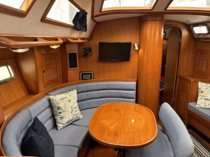 Seacape Yacht Photos Pics Interior of a 1996 Hylas 46 yacht with cozy seating and wooden table.