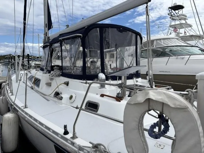 Seacape Yacht Photos Pics Sailboat docked at marina, Hylas 46 model, 1996, with blue canopy and clear skies.