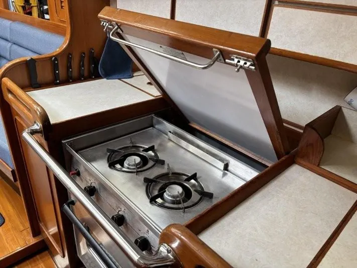 Seacape Yacht Photos Pics Hylas 46 yacht kitchen with two-burner stove, wooden cabinetry, and knife storage, 1996 model.