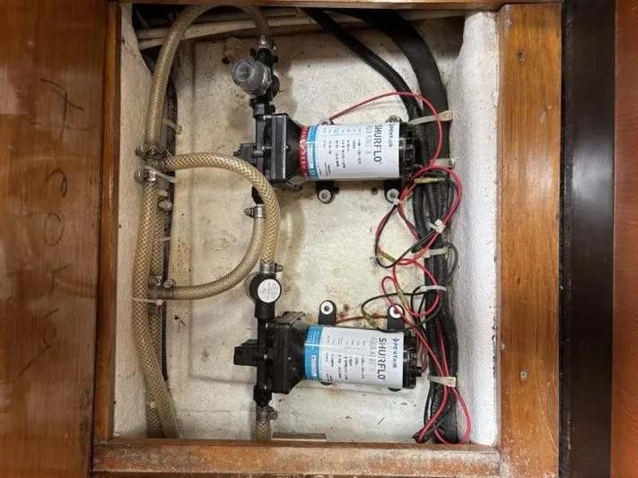 Seacape Yacht Photos Pics Water pump system inside a 1996 Hylas 46 yacht, featuring hoses and wiring.