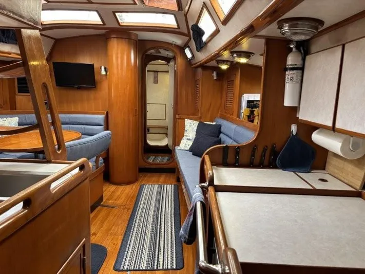 Seacape Yacht Photos Pics Interior of a 1996 Hylas 46 yacht with wood finish and blue seating.