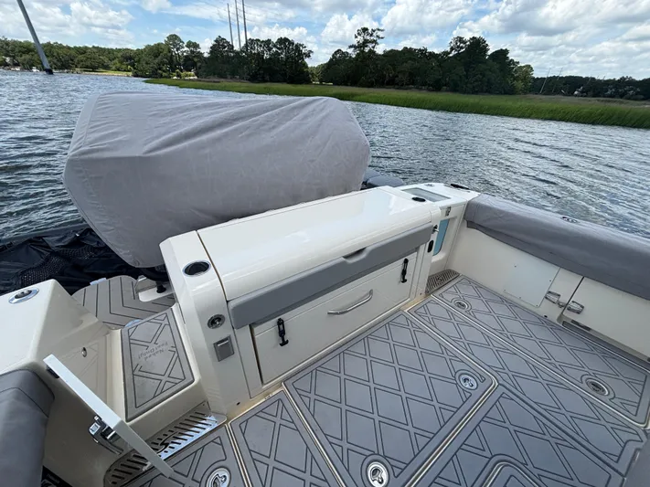 Maryanray Yacht Photos Pics 2024 Scout 377 LXF boat interior with covered seating and storage, on a scenic waterway.