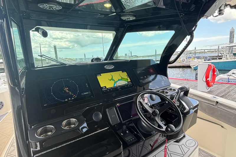 Maryanray Yacht Photos Pics 2024 Scout 377 LXF boat dashboard with navigation screens and steering wheel at marina.