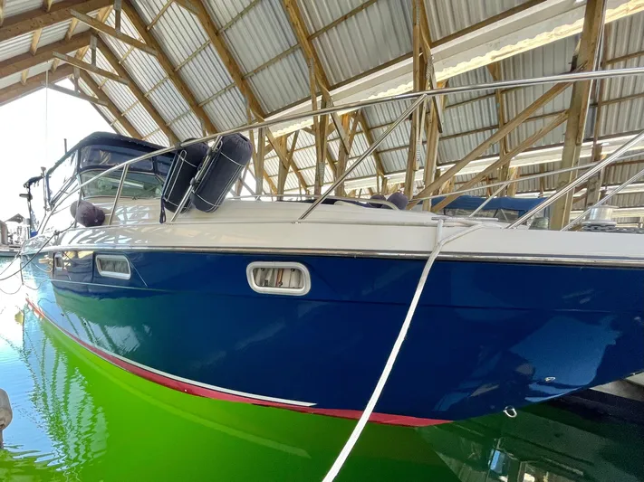 Hailey Brae Yacht Photos Pics 2021 Custom Express Cruiser docked in a covered marina, featuring a sleek blue hull.