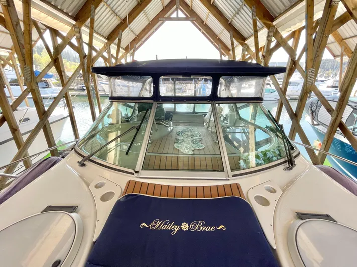 Hailey Brae Yacht Photos Pics 2021 Custom Express Cruiser docked in a wooden boathouse, featuring a spacious deck.