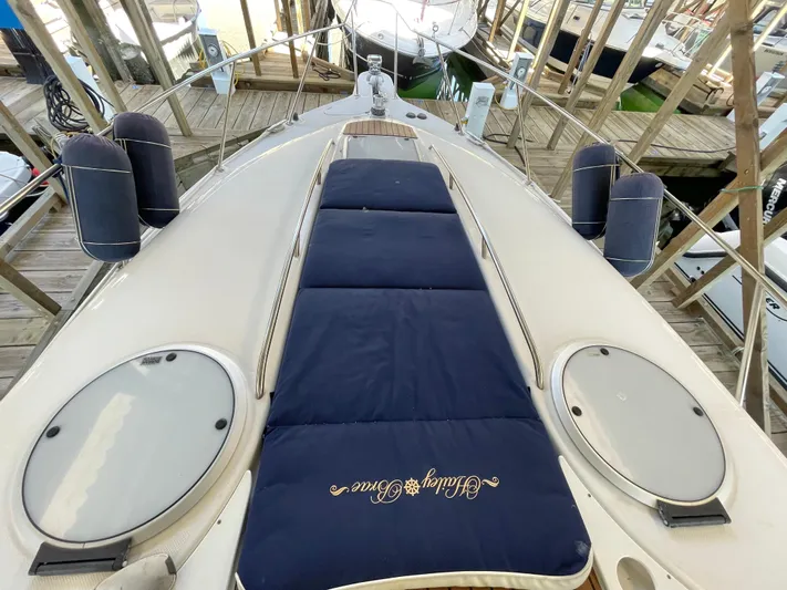 Hailey Brae Yacht Photos Pics 2021 Custom Express Cruiser boat deck with navy cushions and docked at a marina.