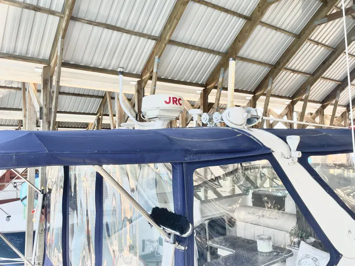 Hailey Brae Yacht Photos Pics 2021 Custom Express Cruiser under a metal roof, featuring radar and antennas.