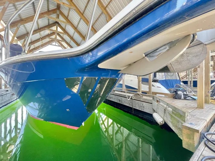 Hailey Brae Yacht Photos Pics Blue 2021 Custom Express Cruiser docked in a covered marina with green water.