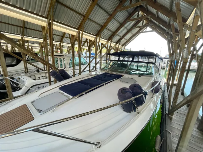 Hailey Brae Yacht Photos Pics 2021 Custom Express Cruiser docked under wooden shelter.